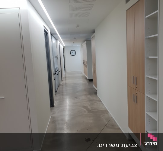 מסדרון עם קירות צבועים בלבן ותקרה מוארת
